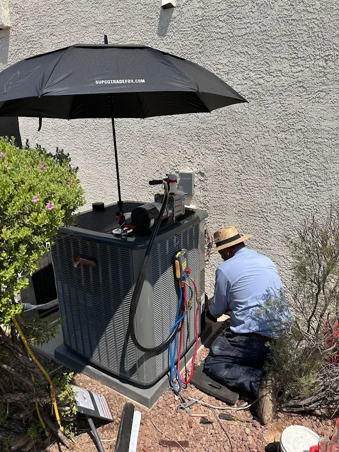 HVAC technician performing outdoor AC maintenance in Portales